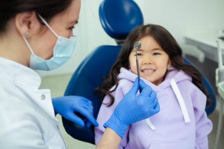 Dentist showing a dental tool to patient