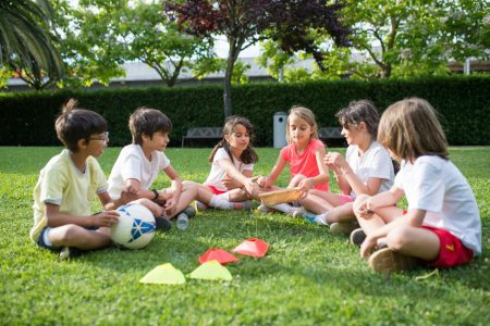 Kids playing while sitting on the green grass